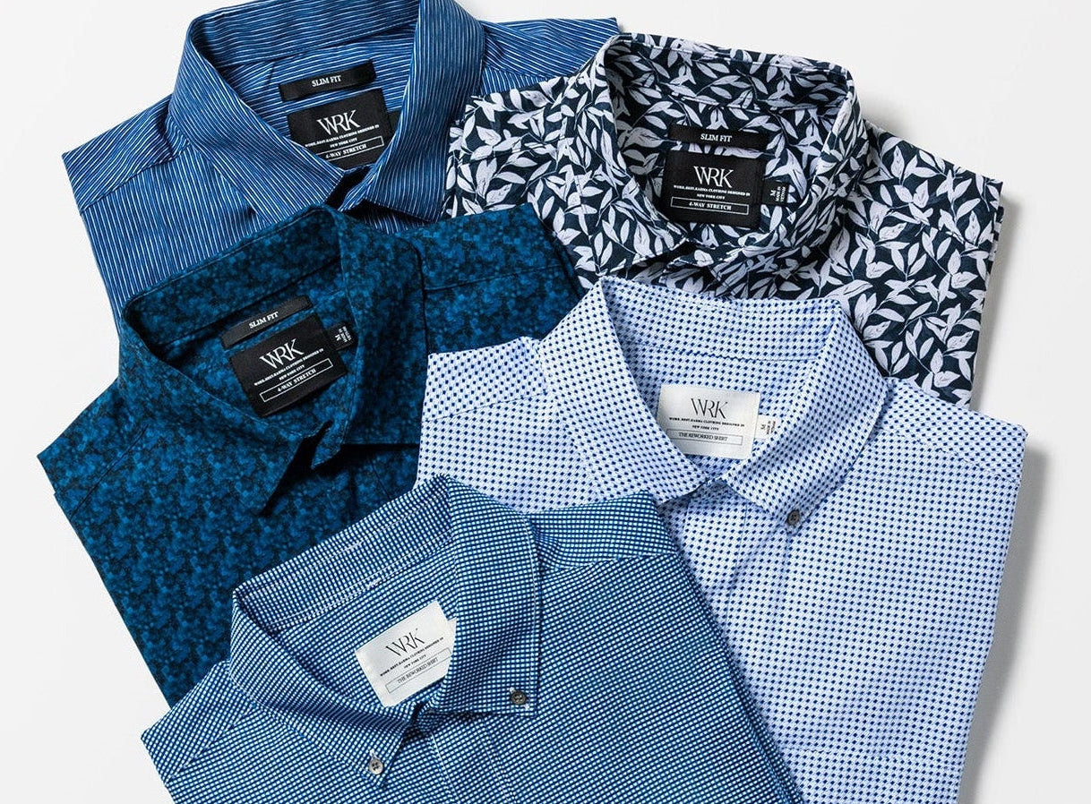 Folded shirts in various blue tones on a white background