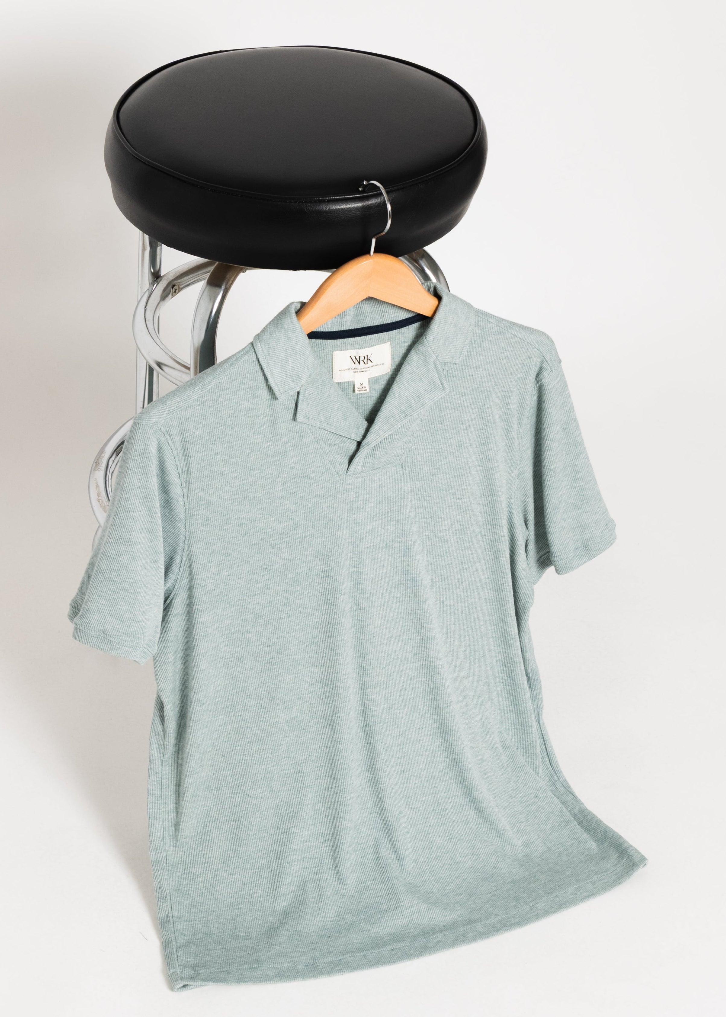 Light blue t-shirt on a black hanger against a white background